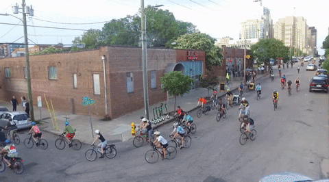 A gif of a large group riding bikes downtown to celebrate Bike Month.